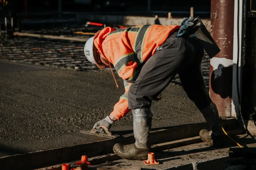 worker laying out concrete